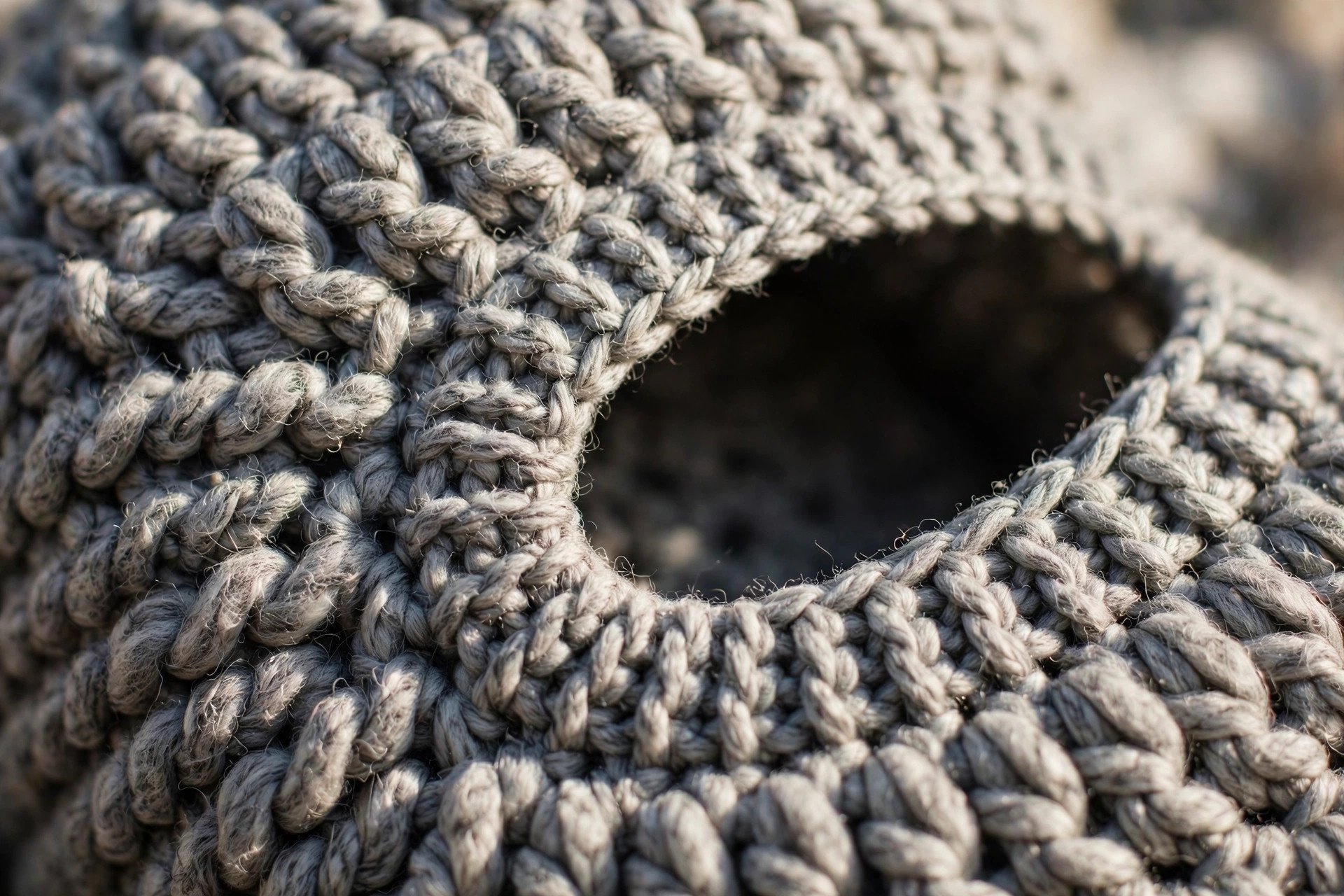 Close-up macro detail of chunky half double crochet stitches and the ribbed edge of the face opening on a handmade grey crochet balaclava, free crochet balaclava pattern