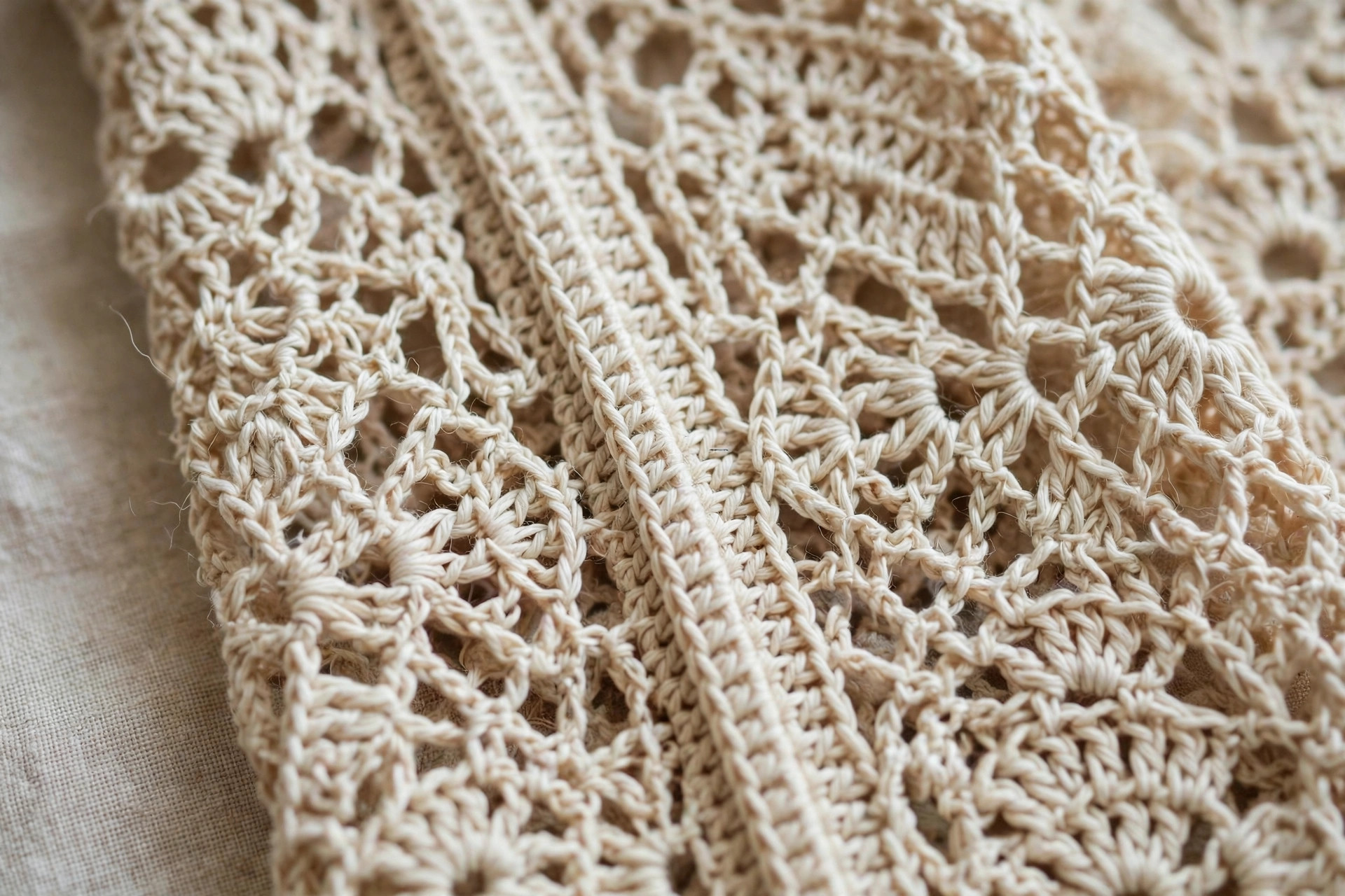 Close-up of a crochet shrug sleeve seam showing the lacy V-stitch pattern and neat seaming