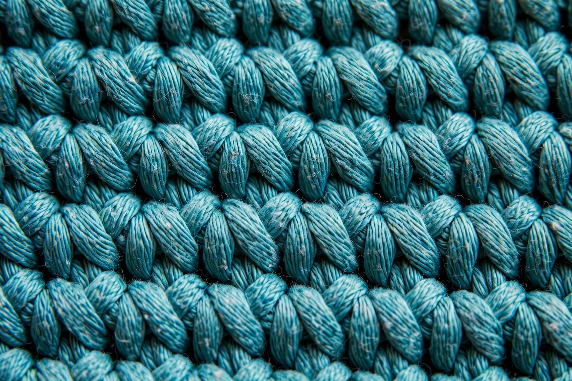 Close-up of firm single crochet stitch texture in teal cotton-blend yarn showing dense, even stitches ideal for swimwear