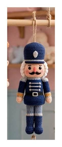 Finished Nutcracker ornament — navy uniform with white chest braid, gold buttons, tall navy hat, straight torso and legs with grey accents and black boots